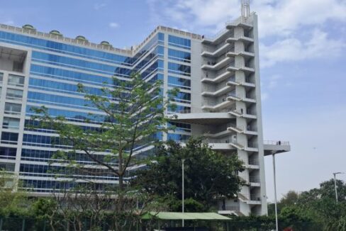 Exterior view of a Grade-A corporate tower in Jasola District Centre featuring a modern glass facade and advanced commercial infrastructure.